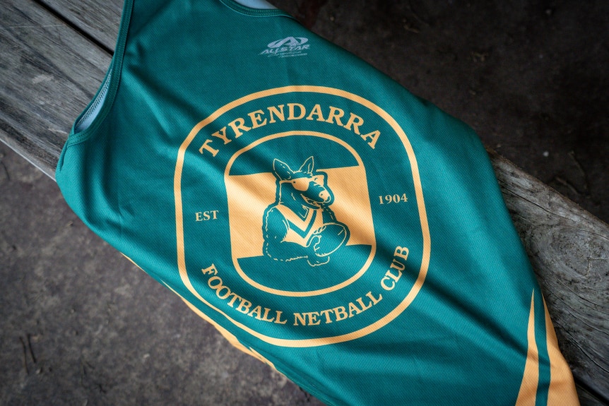 A Tyrendarra Football Netball Club training jumper can be seen on a timber bench.