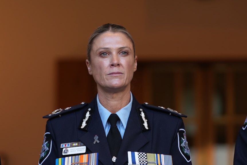 A woman wearing police commissioner uniform addresses the media.