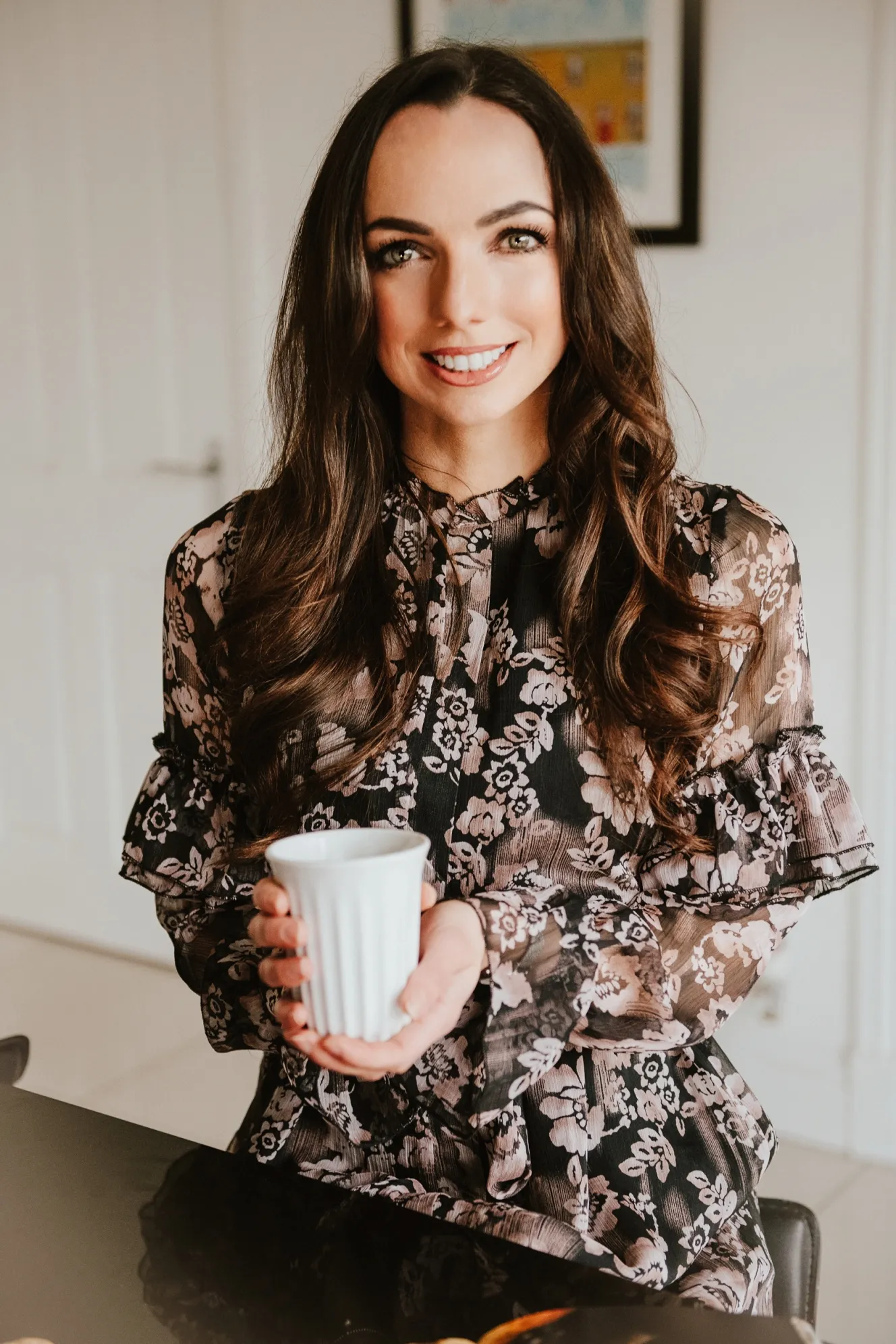 Nichola Ludlam-Raine, a specialist registered dietitian, smiles while holding a white ribbed mug.