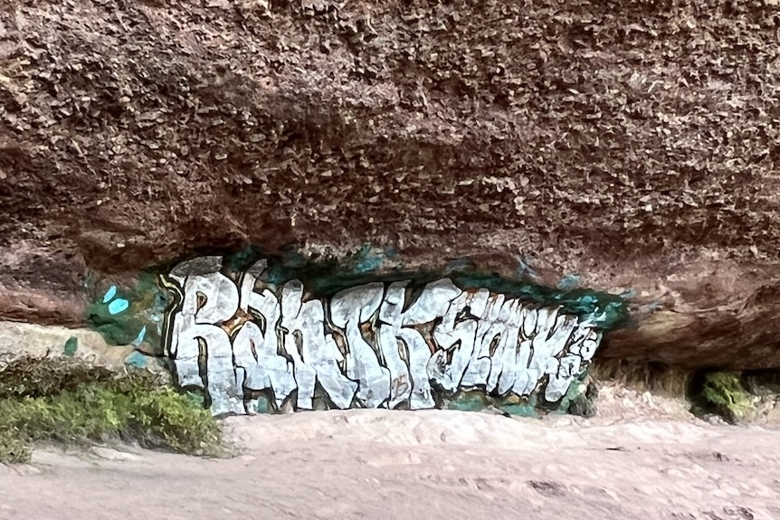 A wide shot of graffiti on a rock face.