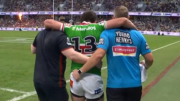 Adam Elliott is assisted off the field by trainers.