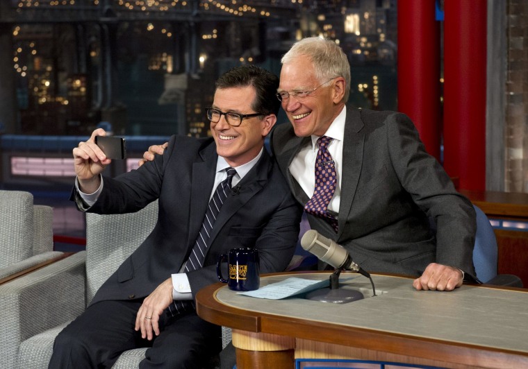 Stephen Colbert poses with David Letterman on "The Late Show" in 2014. 