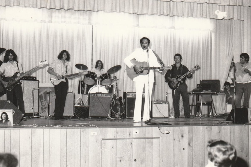 Black and white photo of a band performing on stage.