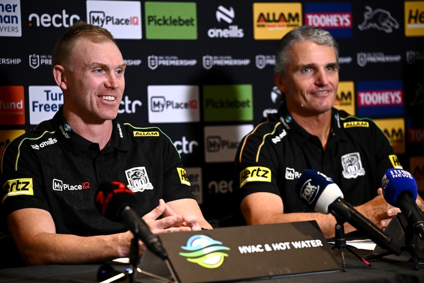 Two men sit at a rugby league press conference 