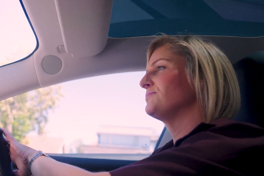 Woman with blonde hair driving a car