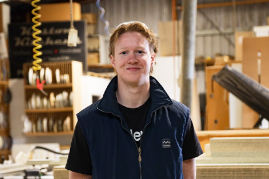 A man stands in a woodworking factory