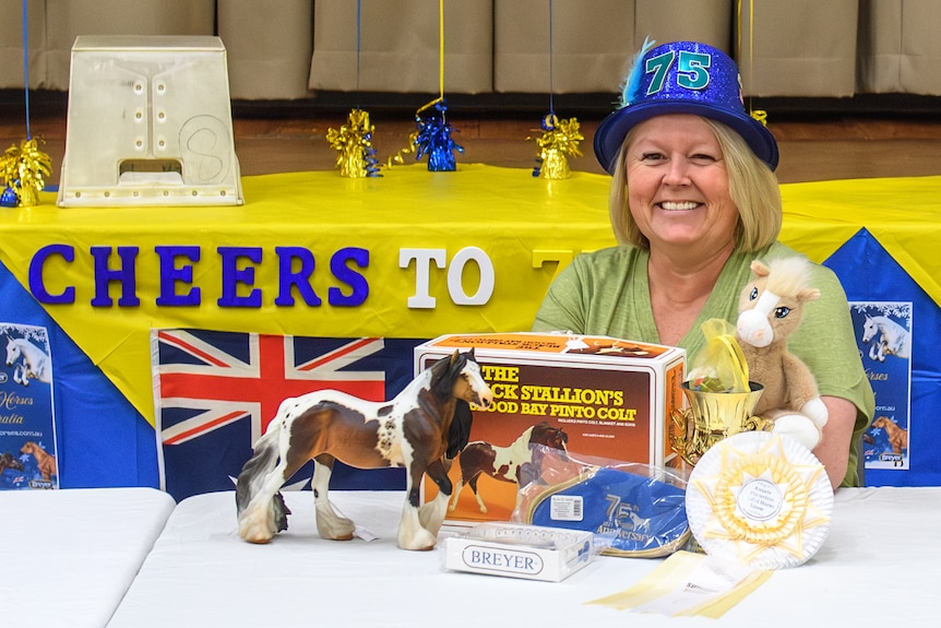 Kerri Afford in a blue hat and model horse on table