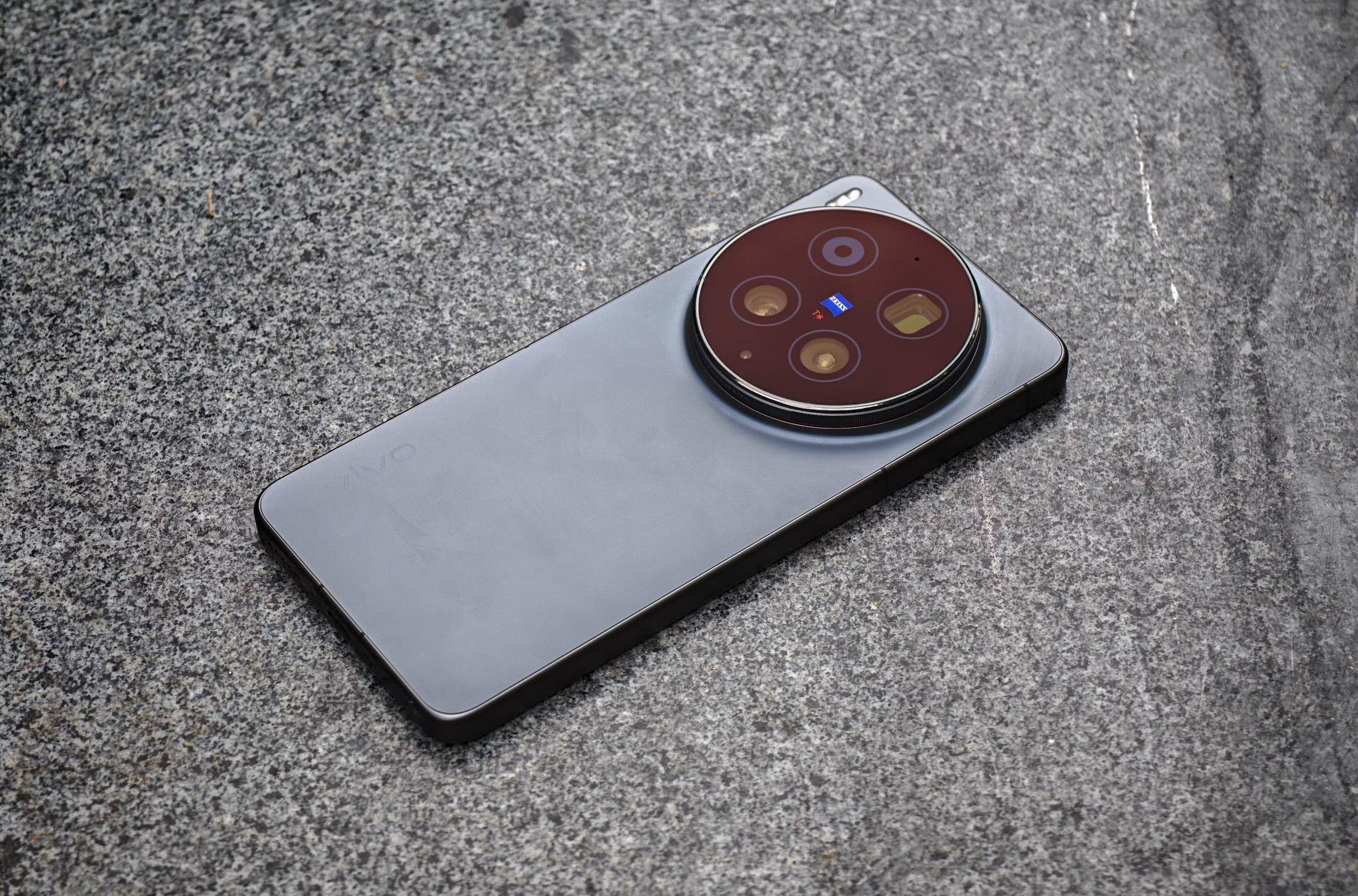 Photo of the Vivo X300 Ultra laying on a gray stone bench.