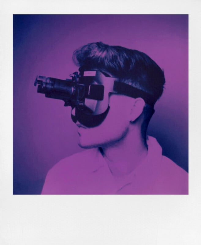 A person wearing a futuristic headset with large lenses, facing left. The image has a purple and pink overlay, giving it a modern, surreal appearance. The individual has short hair and is dressed in a collared shirt.