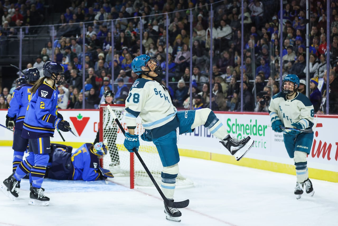 A hockey player cheers and throws her head back.