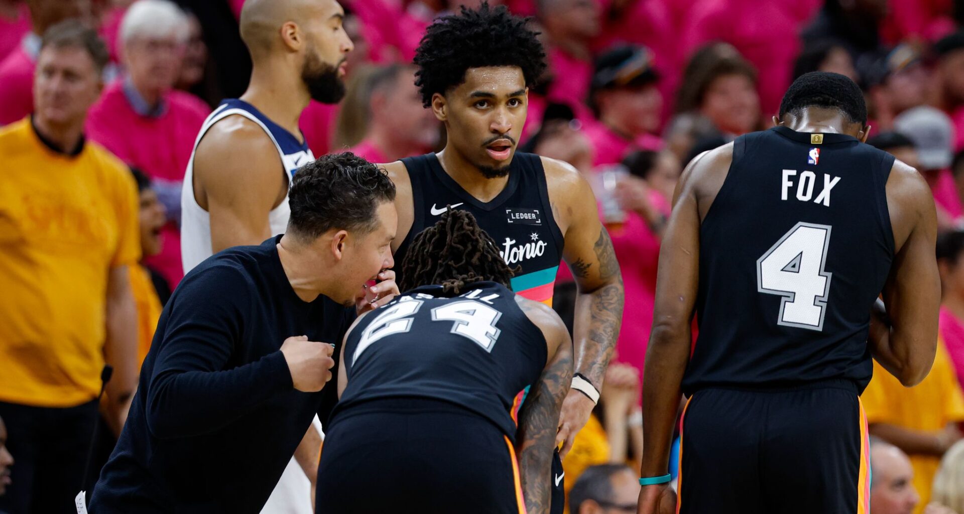 San Antonio Spurs head coach Mitch Johnson, from left, talks to guard Devin Vassell (24), guard Dylan Harper (2) and guard De'aaron Fox (4) during the fourth quarter of Game 1 of the Western Conference semifinals against the Minnesota Timberwolves at Frost Bank Center in San Antonio, Monday, May 4, 2026. The Spurs could be without both Harper and Fox in Game 3 of the Western Conference finals against the Oklahoma City Thunder on Friday. Fox has missed the first two games of the series with a right ankle sprain, while Harper left Game 2 early and didn't return. Both are listed as questionable.