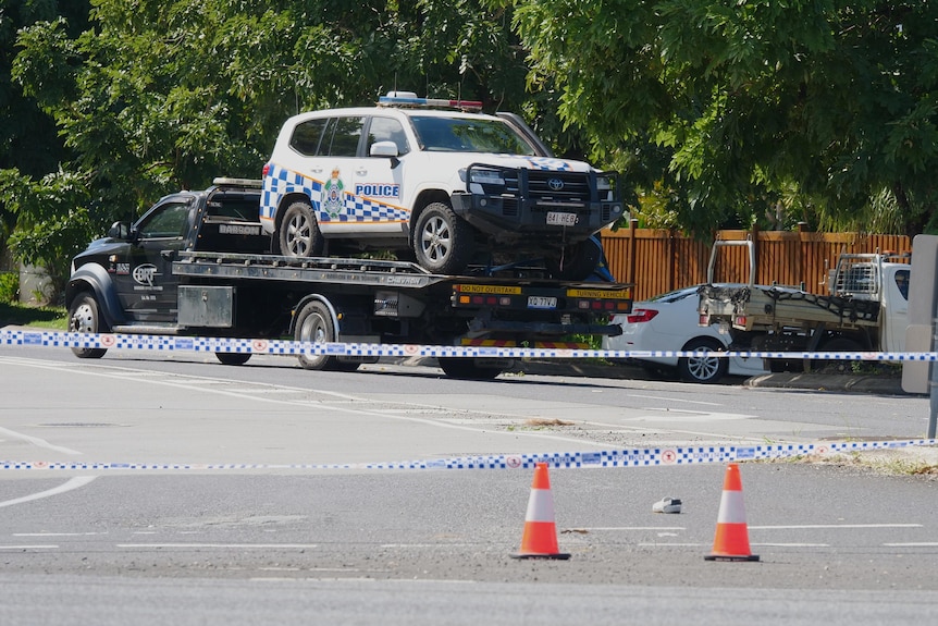 A police marked car loaded on a toe truck and a shoe on the road.