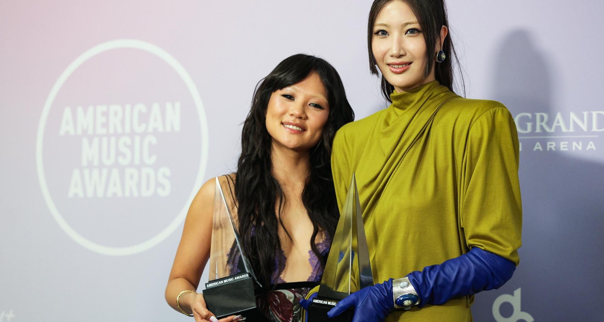 Singers Rei Ami, left, and EJAE hold the award for Song of the Year for