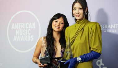 Singers Rei Ami, left, and EJAE hold the award for Song of the Year for