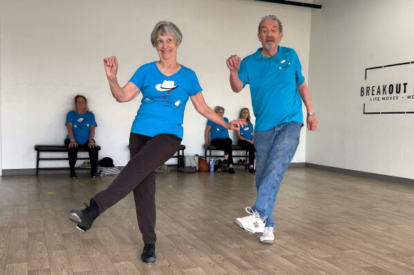 The Rodeo City Wreckettes' Carol Ross 87, and her husband, John, 87, perform a dance to the song, “Let’s Chase Each Other ‘round the Room Tonight" on Thursday, April 16, 2026, in Tucson, Ariz. (Anita Snow via AP) CORRECTION: John Ross' age corrected to 87 from 89.