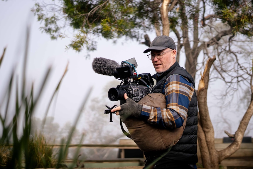 A man filming in a wildlife sanctuary