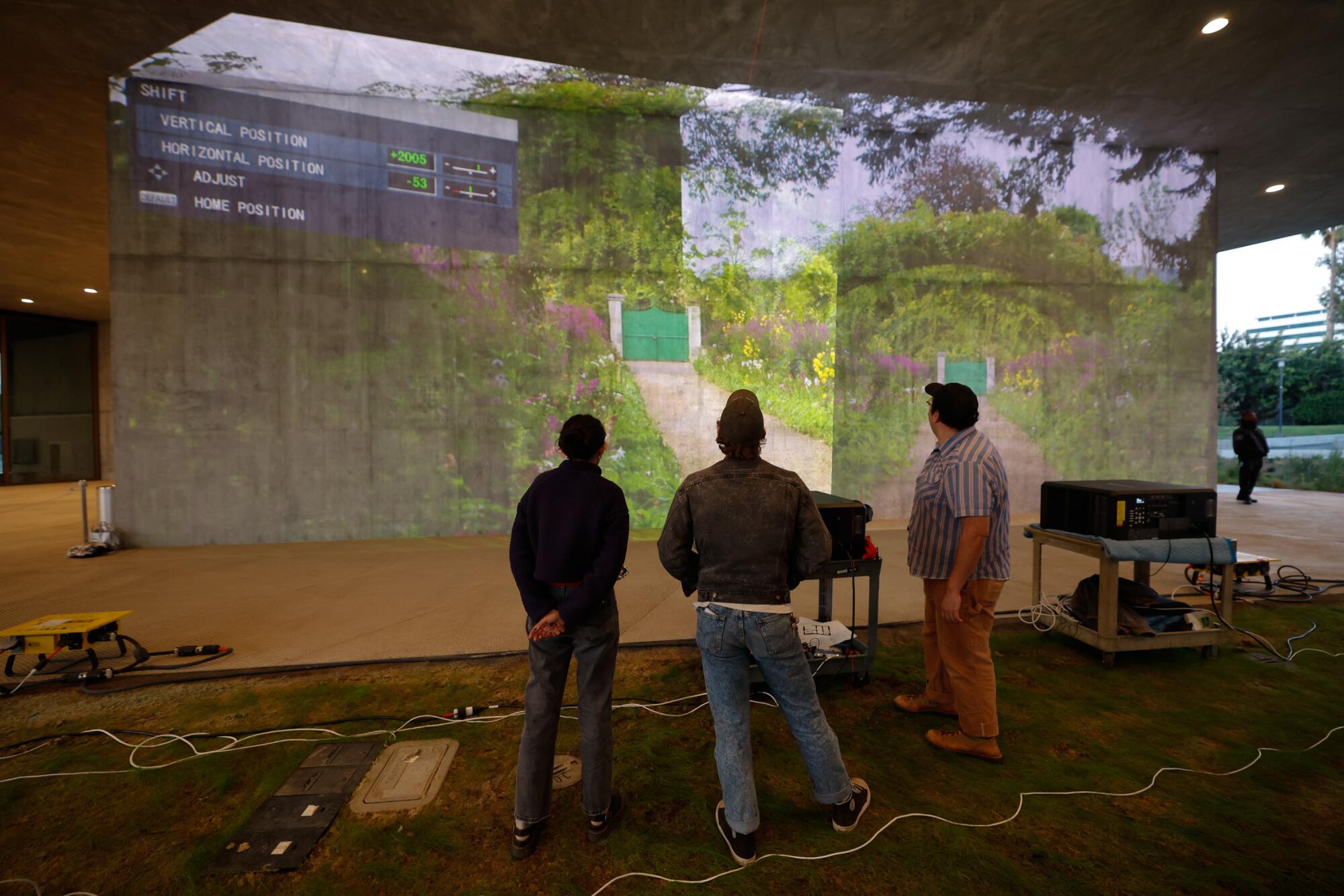 A video installation is tested on a concrete wall.