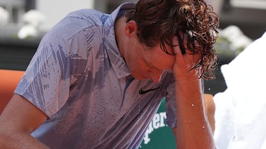 Jannik Sinner tries to cool himself down during a break.