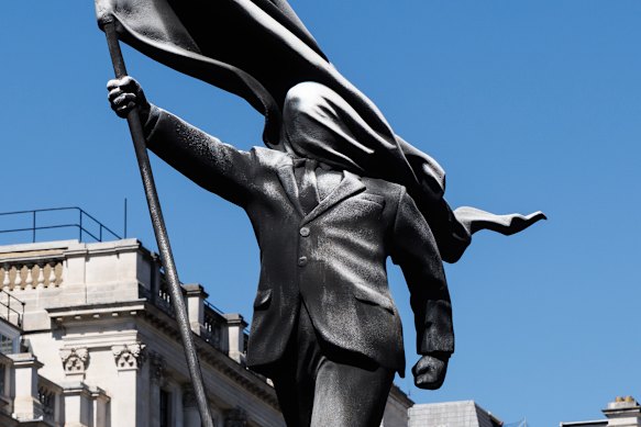 Banksy’s latest pop-up is a statue depicting a person walking from a plinth, his face covered by a billowing flag.