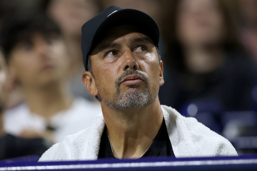 Mariano Puerta wears a cap and looks to his left