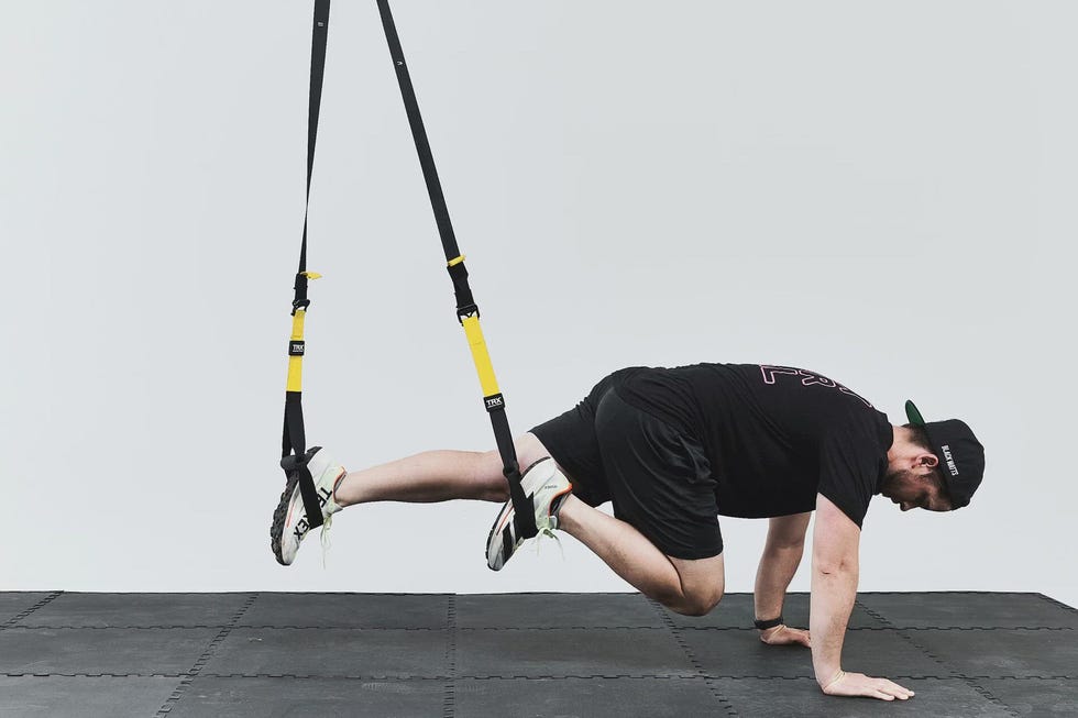 Individual performing an exercise using suspension straps.