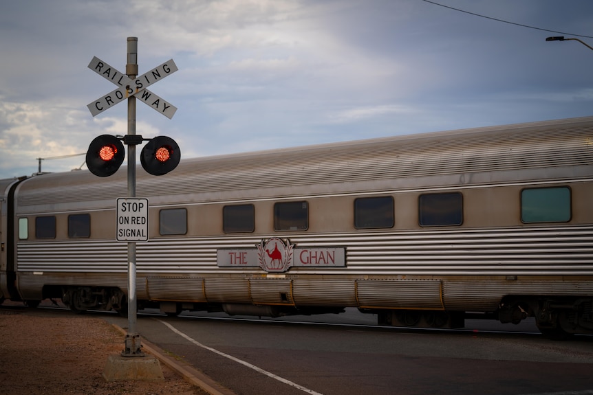 A silver Ghan train carriage goes over a crossing in the vicinity of Port Augusta in SA.