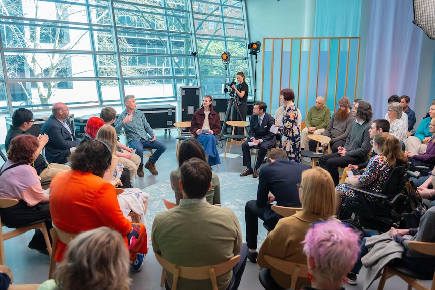 Dave Hughes sits at the centre of a small audience and camera crew