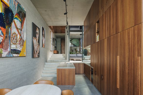 Cowrie Hole house’s kitchen, above the living area, includes a concrete bench as a landing platform between levels.