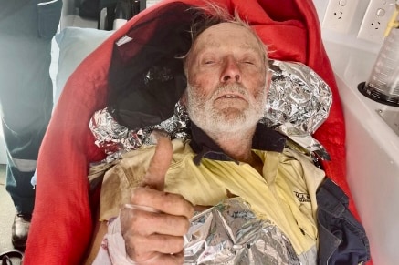 A man in the back of an ambulance gives a thumbs up
