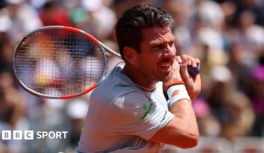 Cameron Norrie watches his shot, with his racquet behind his body