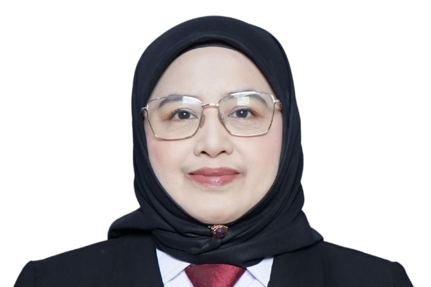 Picture of a middle-aged woman wearing hijab and smiling to the camera