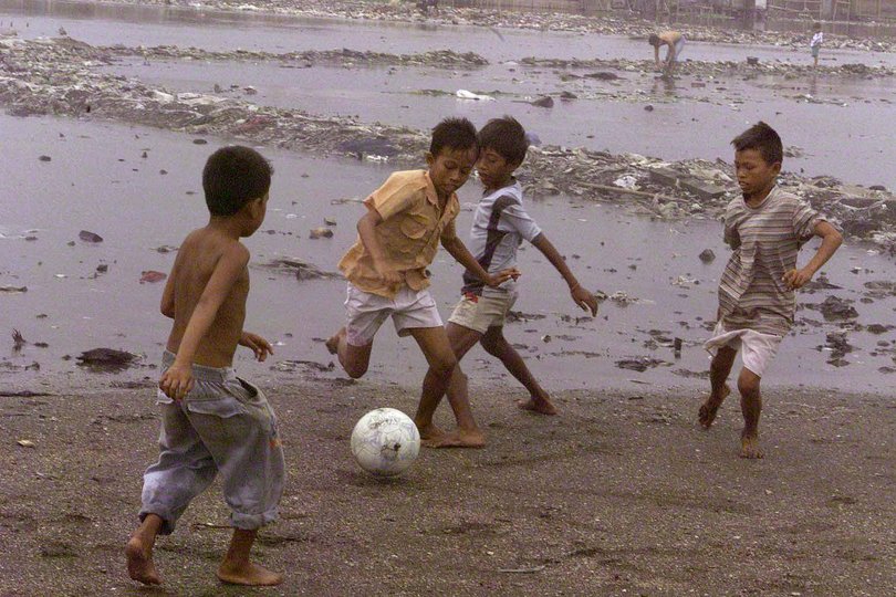 D. KALI BARU (MEANS TWO RIVERS) DISTRICT WHERE THE PEOPLE FIGHT THE RISING RIVER BY BUILDING LEVYS. TRYING TO COMBAT RUBBISH AND POLLUTION KIDS PRACTICE THEIR SOCCER. *DIGITAL IMAGE* Picture: TONY ASHBY