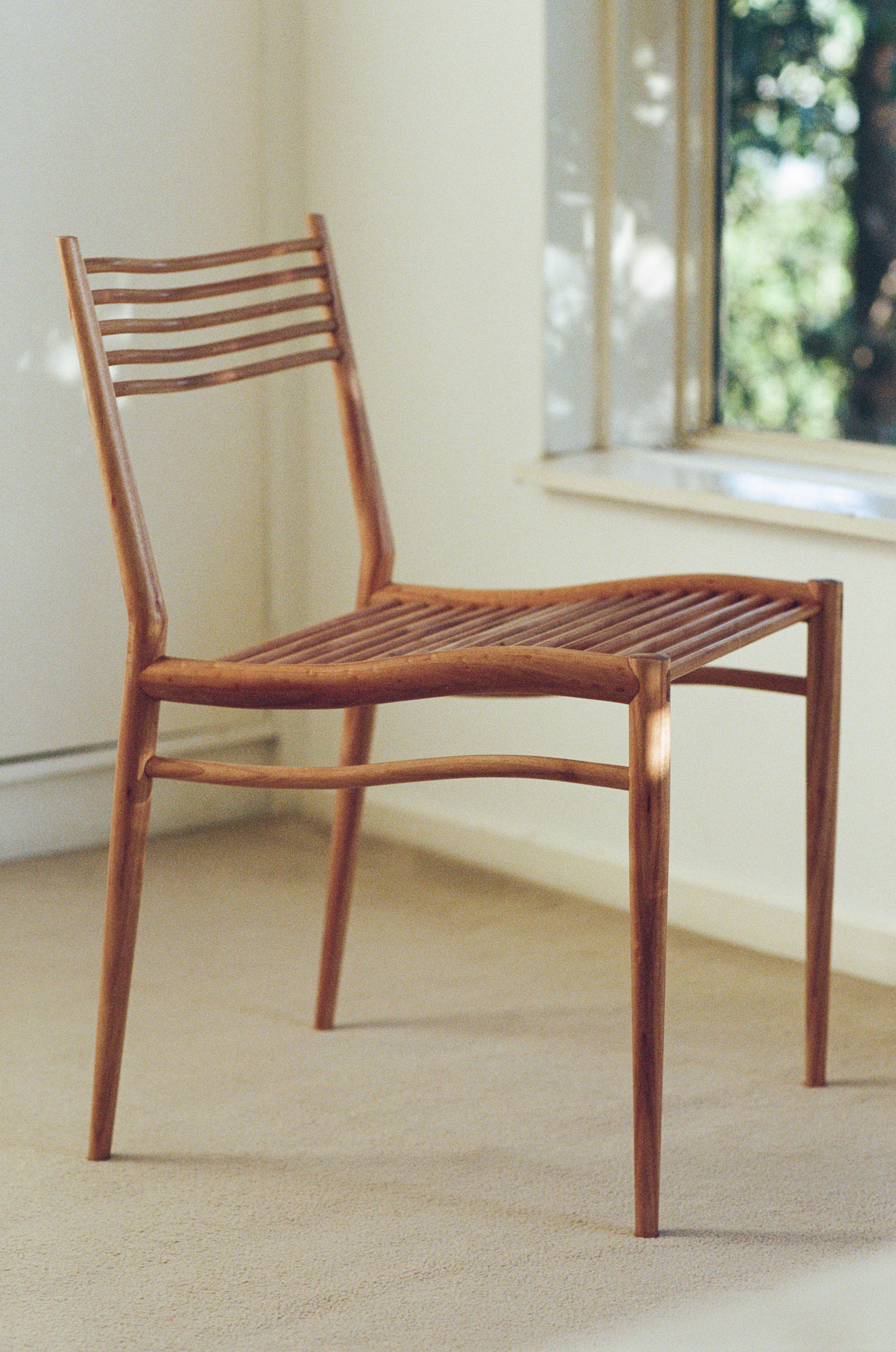 A wooden chair with organic curves to the seat.