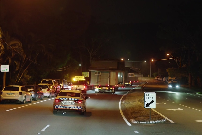 Queenslander home being relocated at night under police escort