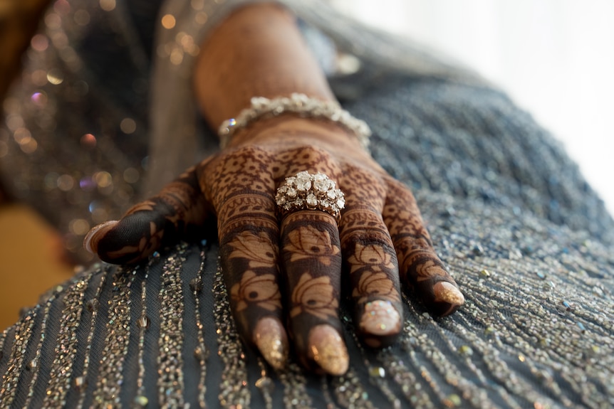 A woman's hands with jewellery and henna. 