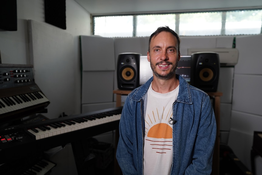 A photo showing a man in studio smiling at the camera