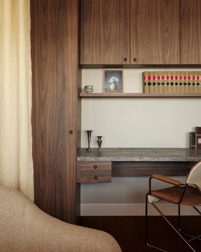 A modern walnut and marble office space with leather armchair