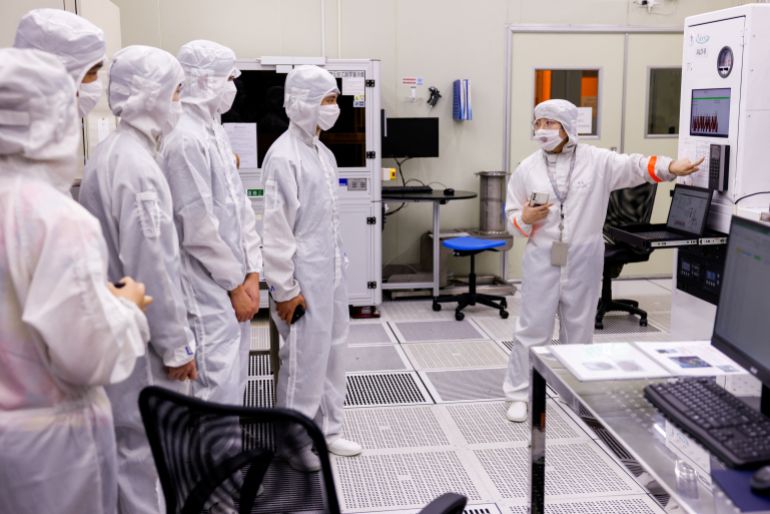 Students dressed in white protective suit and a face mask visit a clean room as part of a summer camp organised by U.S. chip designer Synopsys with the goal to attract more youth to Taiwan's semiconductor industry, in Hsinchu, Taiwan July 18, 2025. REUTERS/Ann Wang