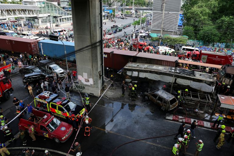 Emergency services work at a site where a train collided with a bus, several cars and motorcycles on Asok-Din Daeng Road, causing several casualties, in Bangkok, Thailand, May 16, 2026. REUTERS/Athit Perawongmetha