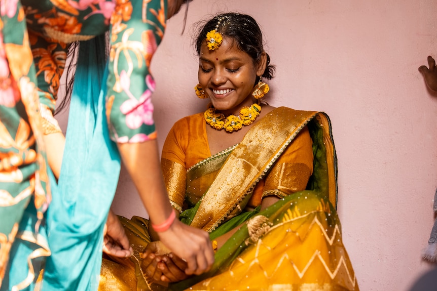 A woman with marigolds around her neck.