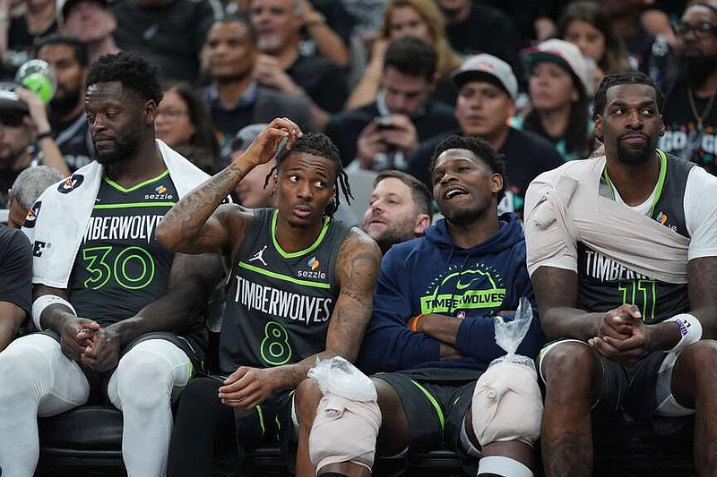 Minnesota Timberwolves forward Julius Randle (30), guard Bones Hyland (8), guard Anthony Edwards (5) and center Naz Reid (11) watch from the bench during the second half in Game 2 of a second-round NBA playoffs basketball series against the San Antonio Spurs in San Antonio, Wednesday, May 6, 2026. (AP Photo/Eric Gay)