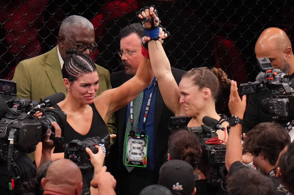 Ronda Rousey, of the United States, right, celebrates after defeating Gina Carano, of the Unite ...