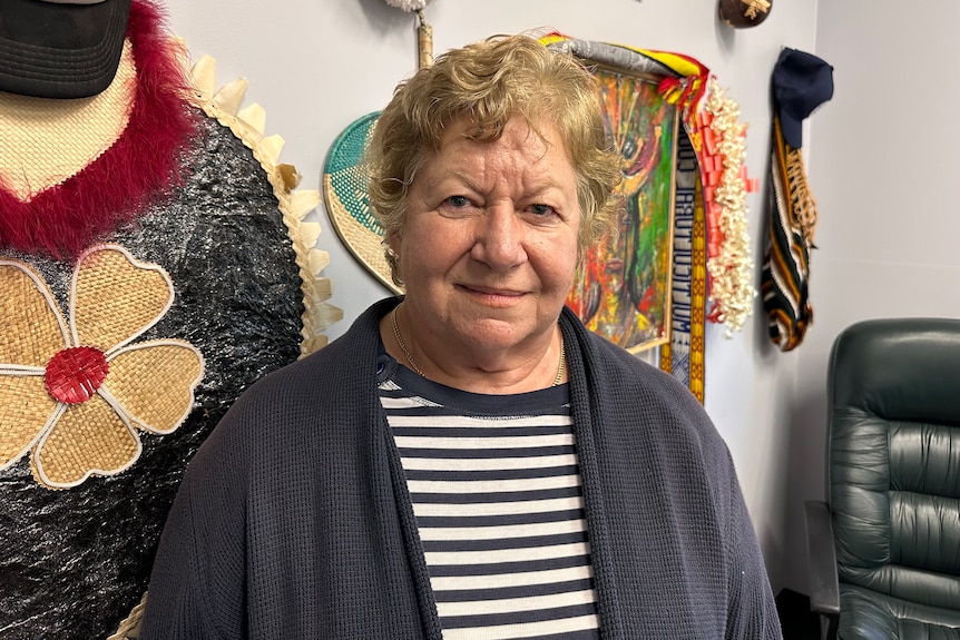 Woman in stripey top looks seriously at camera.