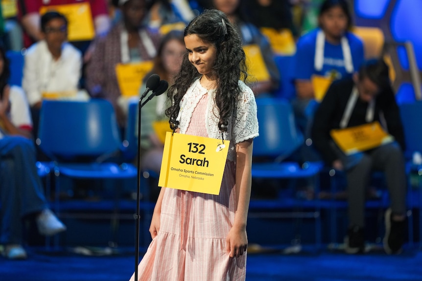 A girl stands on stage in front of a microphone