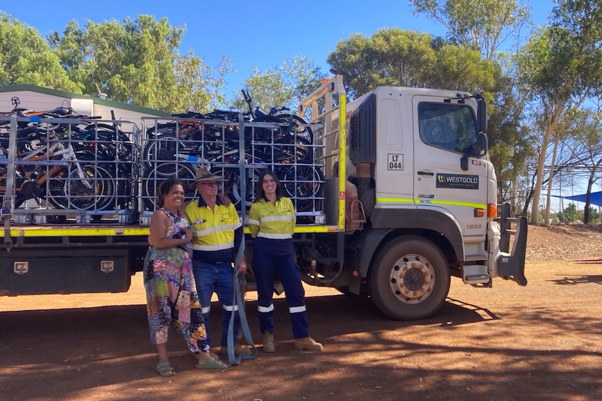 Timika King stands with a man and a woman in front of truck full of bikes