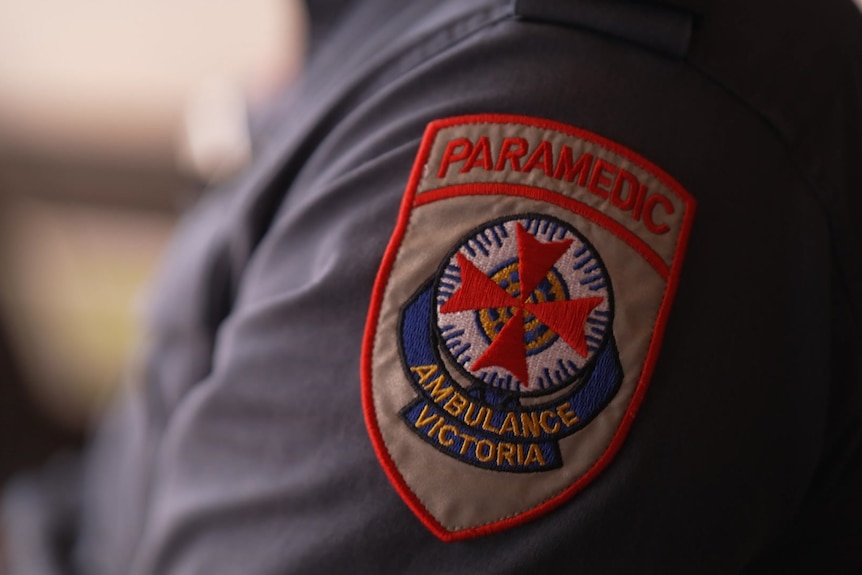 The Ambulance Victoria insignia on the shoulder of a paramedic's shirt.
