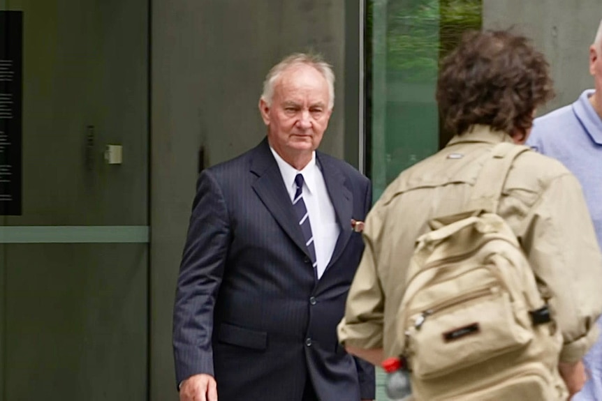 man in a suit coming out of a court building