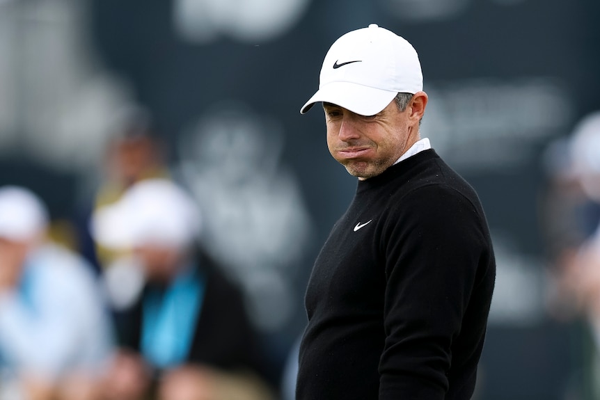 Rory McIlroy puffs out his cheeks and looks down
