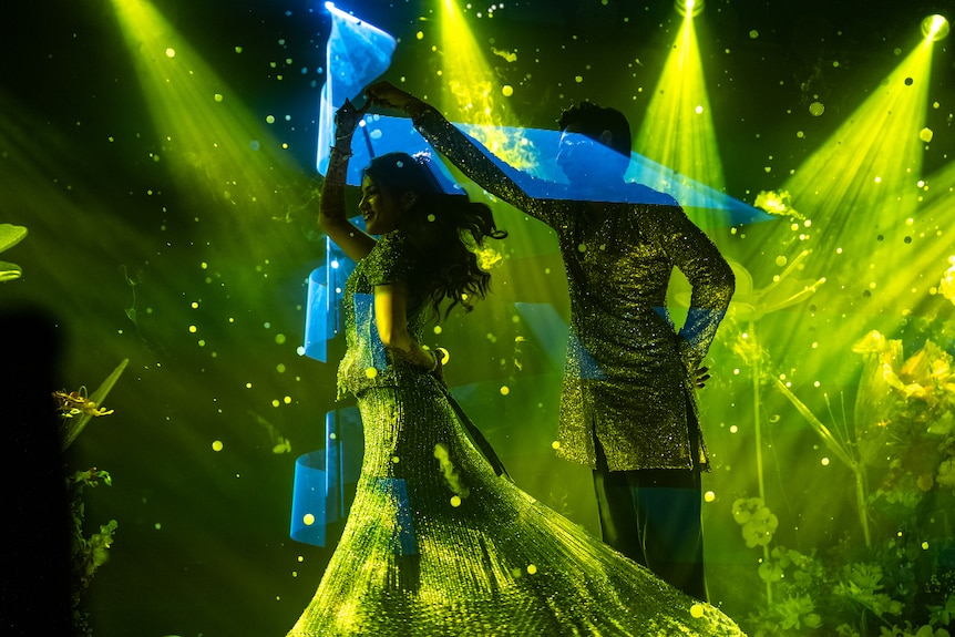 The couple dance on stage.