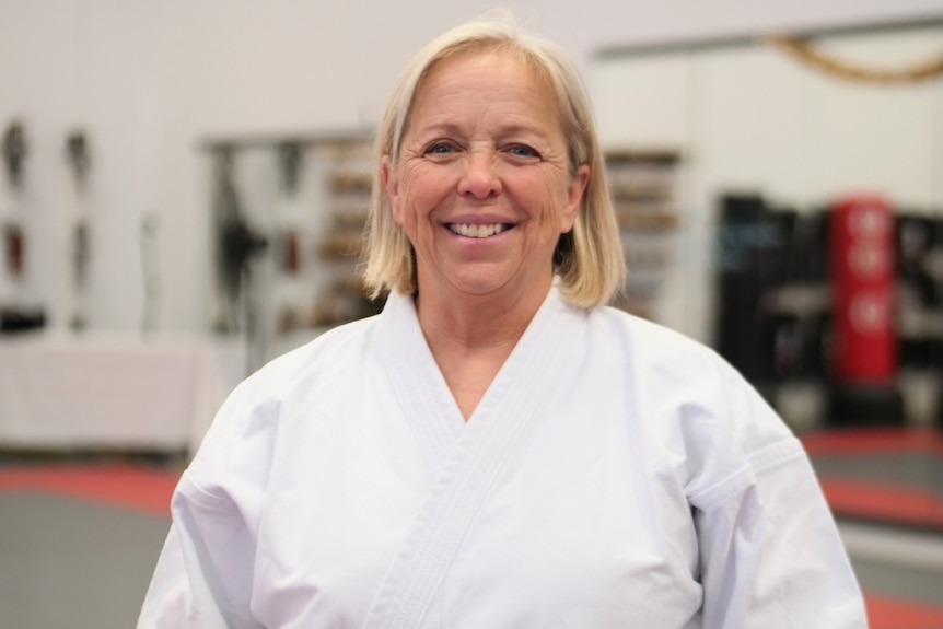 A profile of a woman, smiling with a white karate outfit